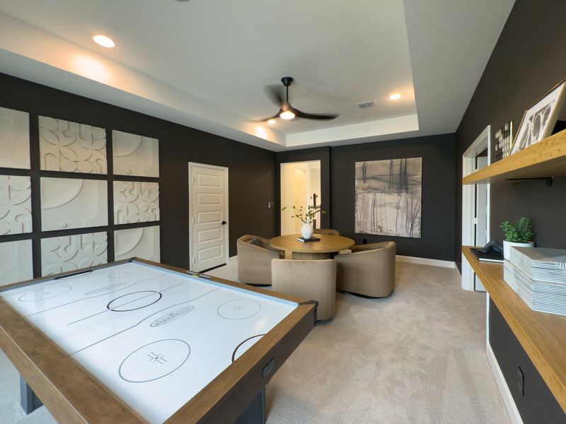 A modern game room with a sleek air hockey table, stylish seating area, and elegant wall art in a cozy setting. A modern game room with a sleek air hockey table, stylish seating area, and elegant wall art in a cozy setting.