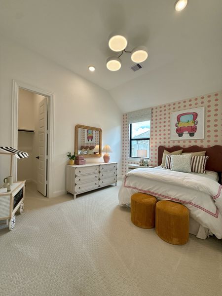 A cozy bedroom featuring playful decor, soft carpeting, and warm lighting with modern accents. A cozy bedroom featuring playful decor, soft carpeting, and warm lighting with modern accents.