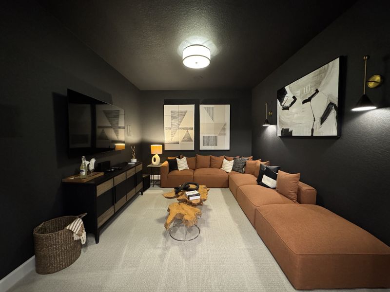 A cozy media room featuring a plush sectional sofa, modern wall art, and ambient lighting for a relaxing atmosphere.