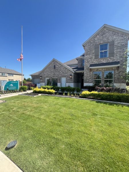 A charming brick home with manicured lawn in Lilyana by M/I Homes, Prosper, TX.
