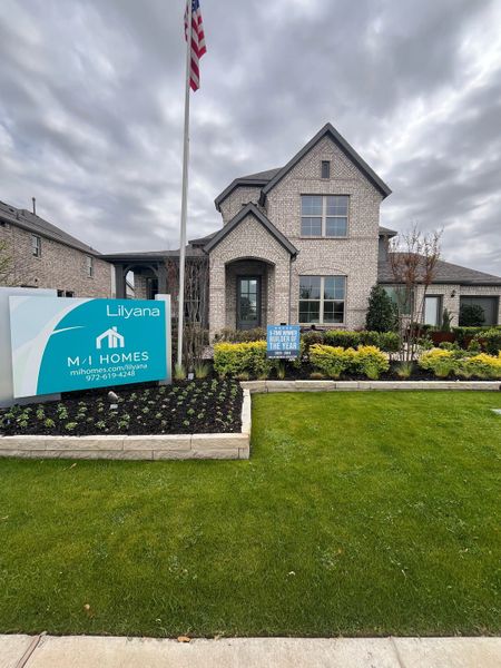 A beautiful brick home with lush landscaping in Lilyana by M/I Homes (Prosper, TX).
