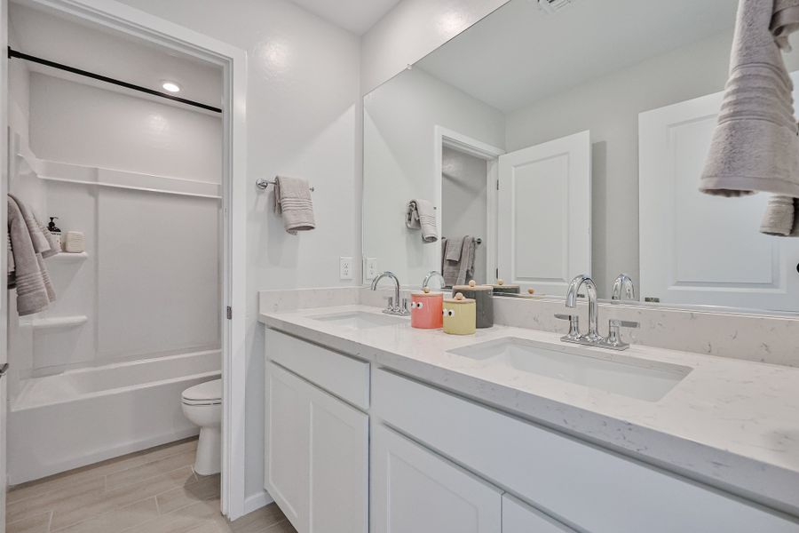 A bathroom with a tub sink and toilet.