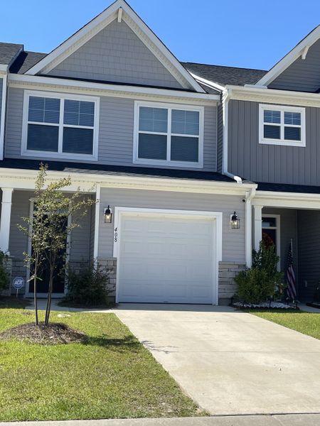 A charming gray townhouse with a manicured lawn in The Landings at Montague by Eastwood Homes (Goose Creek, SC).