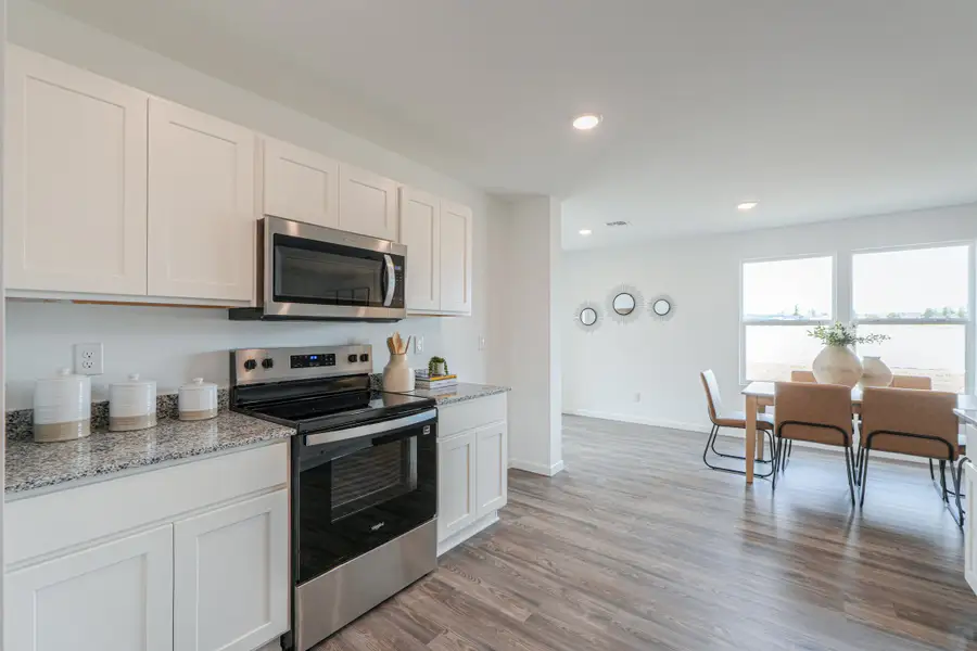 A kitchen with white cabinets.