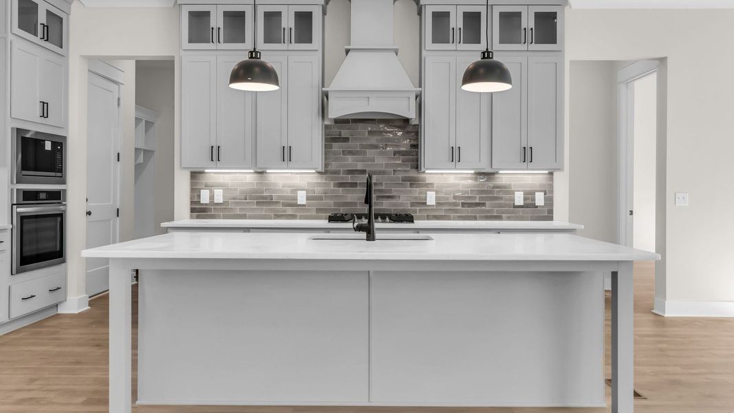 Kitchen with quartz countertops, pendant lighting, and hard surface flooring