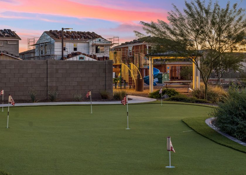 A golf course with a building in the background. A golf course with a building in the background.