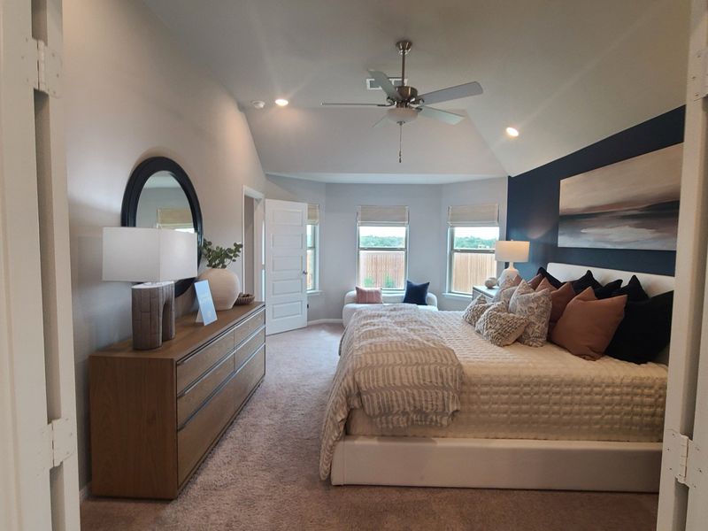 A cozy bedroom featuring a large bed, neutral tones, a stylish dresser with a mirror, and ample natural light. A cozy bedroom featuring a large bed, neutral tones, a stylish dresser with a mirror, and ample natural light.