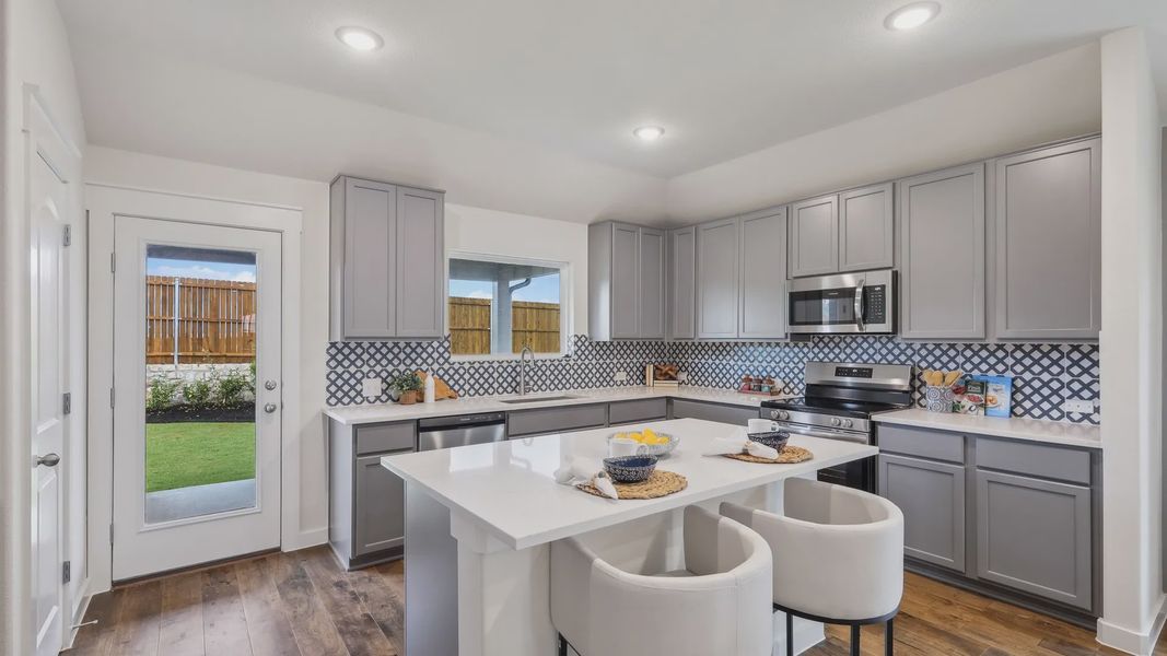 Experience luxury with custom cabinetry, chic patterned backsplash, and rich hardwood floors in Churchill. Experience luxury with custom cabinetry, chic patterned backsplash, and rich hardwood floors in Churchill.