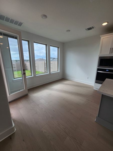 Bright room with hardwood floors, large windows, and modern cabinetry, perfect for a cozy and elegant living space.