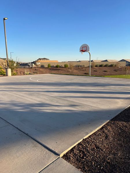 A pristine community basketball court under clear skies in Copper Falls by D.R. Horton (Buckeye, AZ).