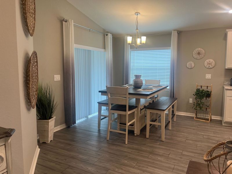 A cozy dining area with elegant lighting, light wood flooring, and natural decor accents for a welcoming ambiance.