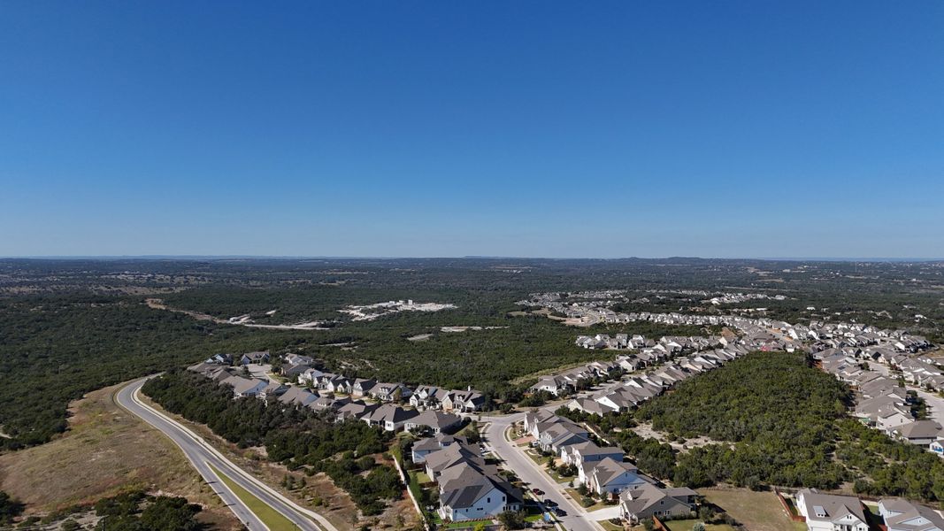 Aerial view of scenic homes amidst lush greenery in Headwaters 50' - Executive Series by David Weekley Homes (Dripping Springs, TX). Aerial view of scenic homes amidst lush greenery in Headwaters 50' - Executive Series by David Weekley Homes (Dripping Springs, TX).