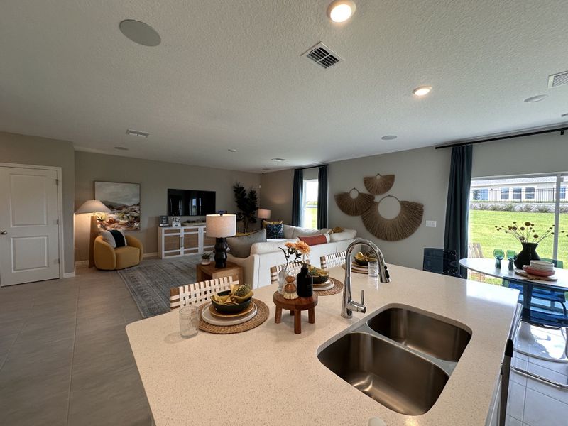 A modern living space with a cozy seating area, decorative wall art, and ample natural light from large windows.