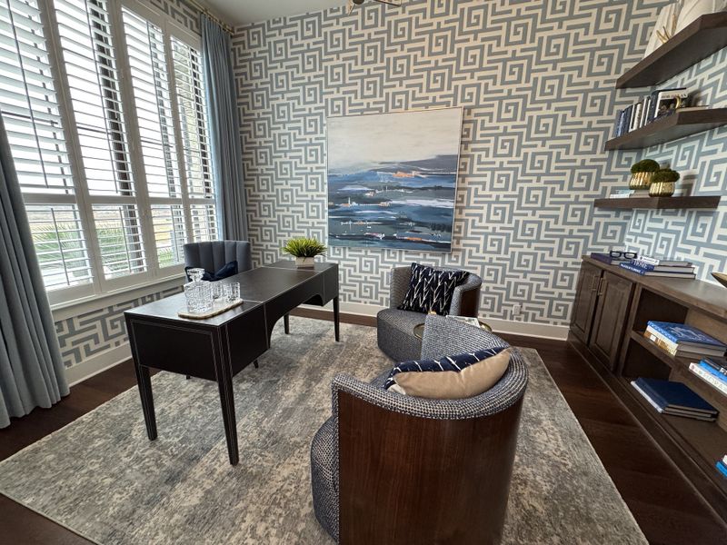 A sophisticated study with patterned wallpaper, elegant curtains, and modern furniture.