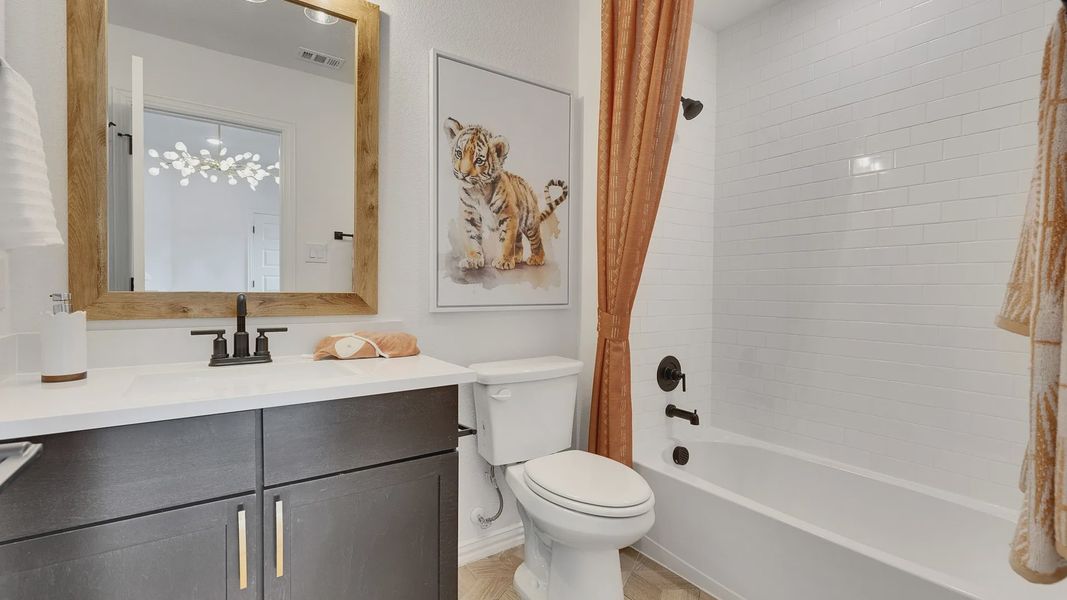 Luxurious bath featuring a chic dark vanity and warm wood accents in Spring Creek.