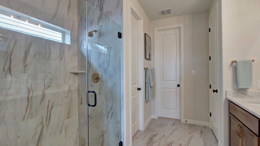 Exquisite marble tiles and gleaming glass shower embody sophistication in Meyer Ranch's Enclave.