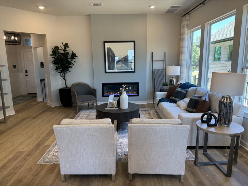 Stylish living area with a cozy fireplace, modern decor, and ample natural light from large windows.