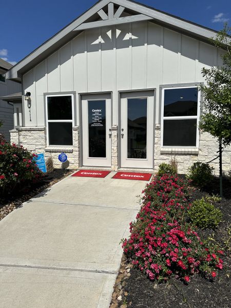 Charming white building with stone accents and vibrant landscaping in Windrow by Centex (Hockley, TX).