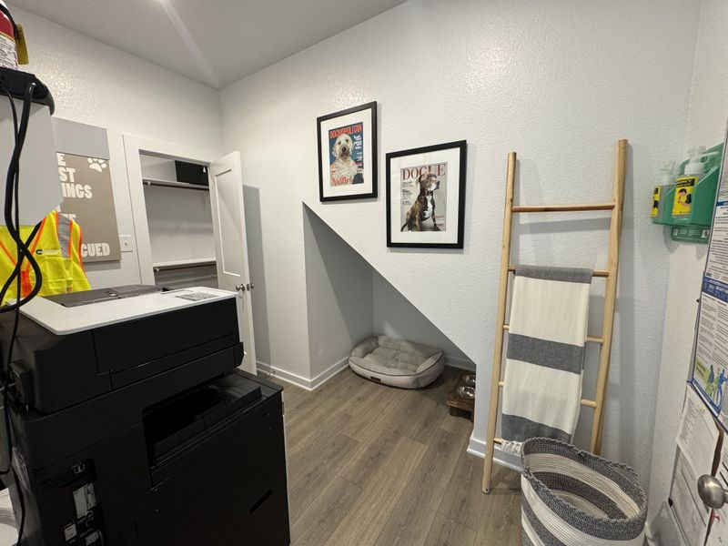 A functional room with a printer, artful dog-themed decor, and ladder rack, showcasing stylish utility and charm. A functional room with a printer, artful dog-themed decor, and ladder rack, showcasing stylish utility and charm.