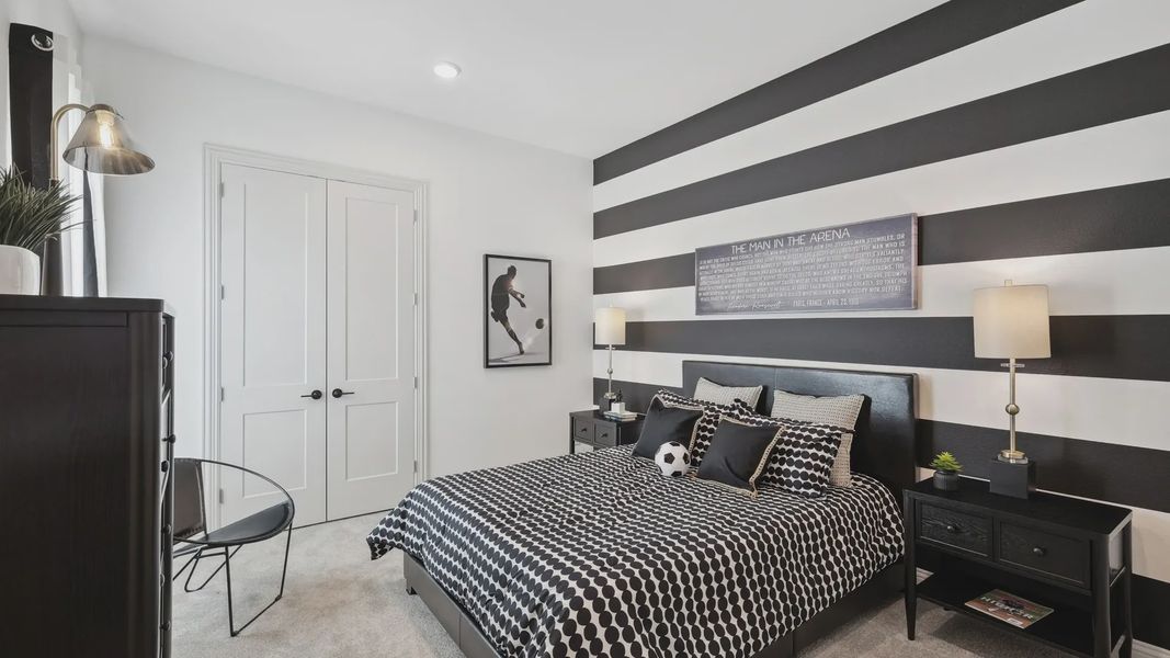Elegant bedroom features striking striped walls, plush carpet, and sleek furniture in Westside Preserve.