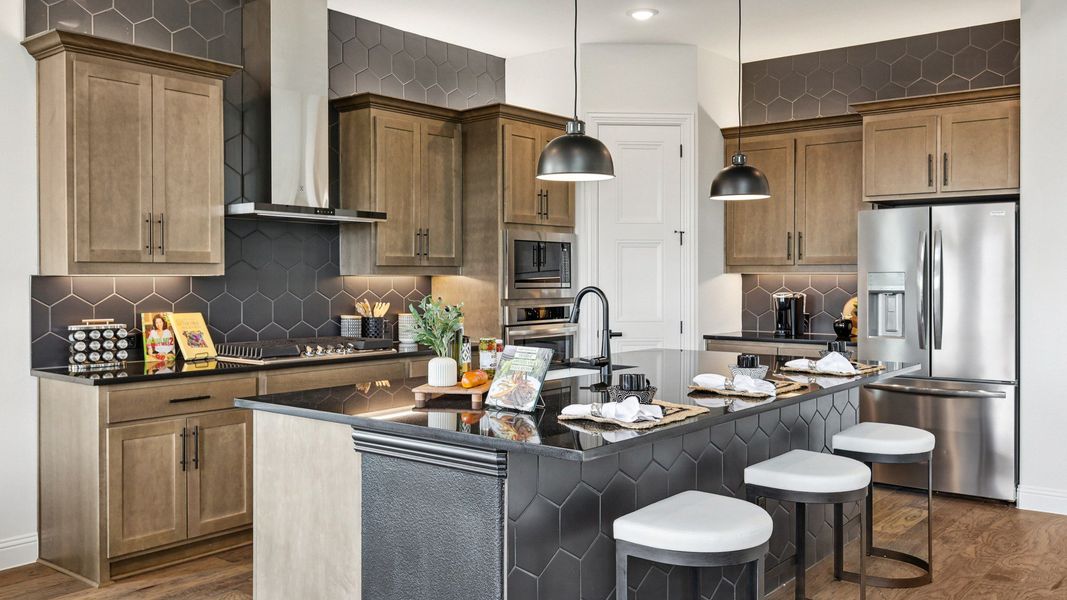 Elegant cabinetry and hex tile complement the sleek island in this Green Meadows kitchen masterpiece.