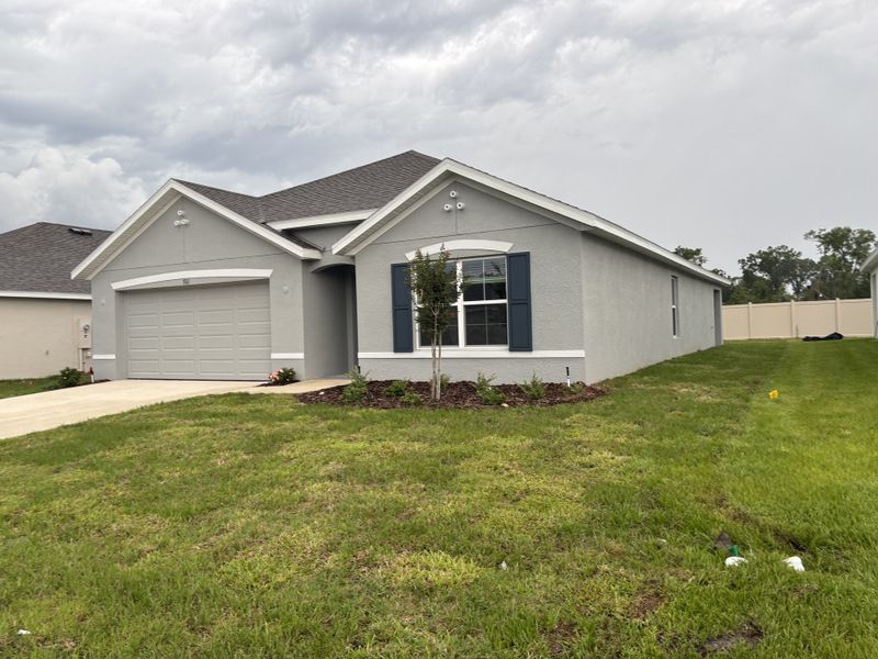 A modern gray home with a spacious yard in Autumn Glen by D.R. Horton (Belleview, FL).