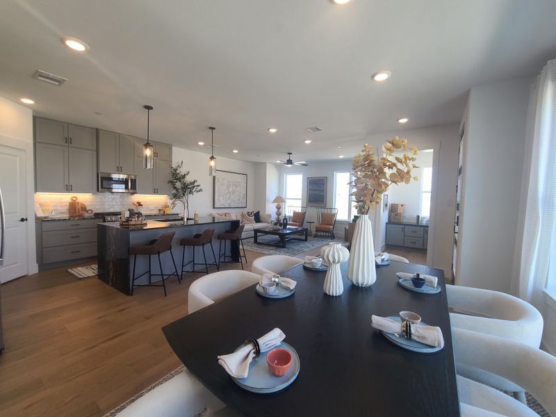 A modern open-concept kitchen and dining area with sleek cabinetry, ambient lighting, and elegant decor. A modern open-concept kitchen and dining area with sleek cabinetry, ambient lighting, and elegant decor.