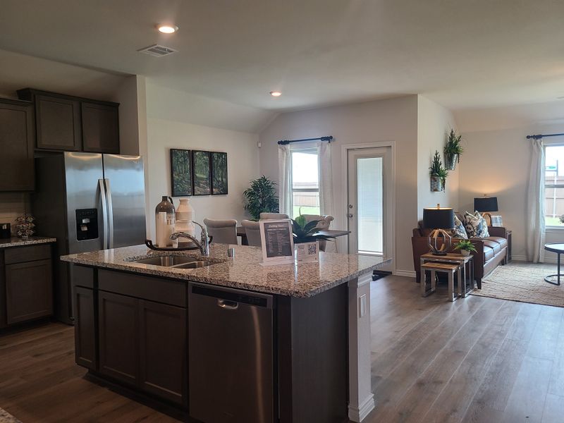 An open living area with a sleek kitchen island, modern stainless appliances, and cozy seating for a stylish ambiance.