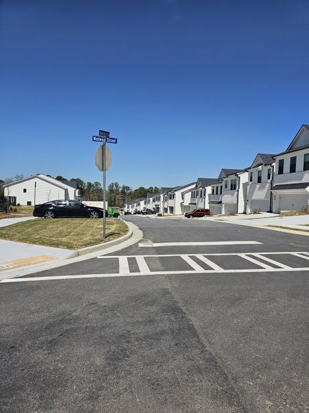 A row of modern townhomes with clean lines and landscaped sidewalks in Azalea Square Townhomes by Century Communities (Lawrenceville, GA). A row of modern townhomes with clean lines and landscaped sidewalks in Azalea Square Townhomes by Century Communities (Lawrenceville, GA).