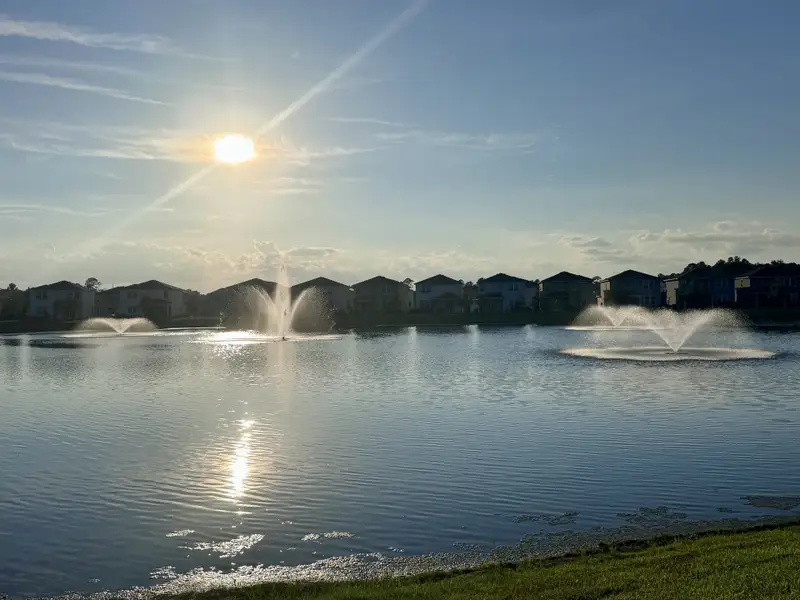 Scenic lake view with elegant fountains at sunset in The Preserve at Bannon Lakes by Pulte Homes (St. Augustine, FL).