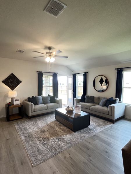 A cozy living room with modern gray couches, a chic coffee table, elegant decor, and soft lighting on a stylish rug.