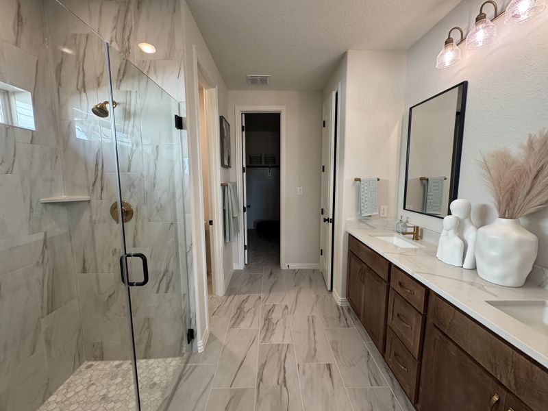 A chic bathroom with a marble-tiled shower, dual sinks, and modern decor accents. A chic bathroom with a marble-tiled shower, dual sinks, and modern decor accents.