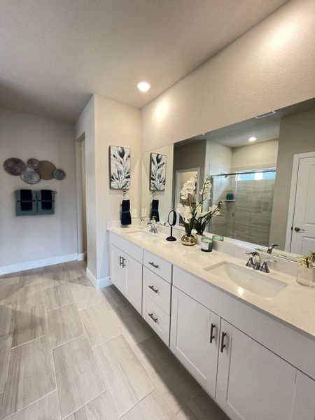 A spacious bathroom with twin vanities, elegant decor, and ample natural light.