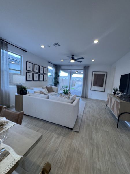 A modern living room with wood flooring, white sofas, gallery wall art, and ample natural light. Perfect for cozy gatherings.
