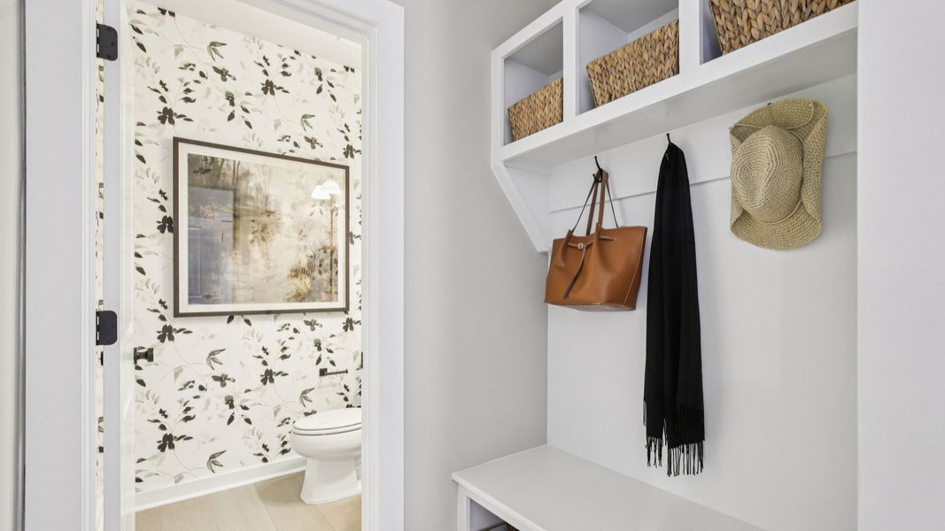 Enjoy the convenience, storage, and custom look of built-in drop zone shelving, bench, and hooks near the garage entry.