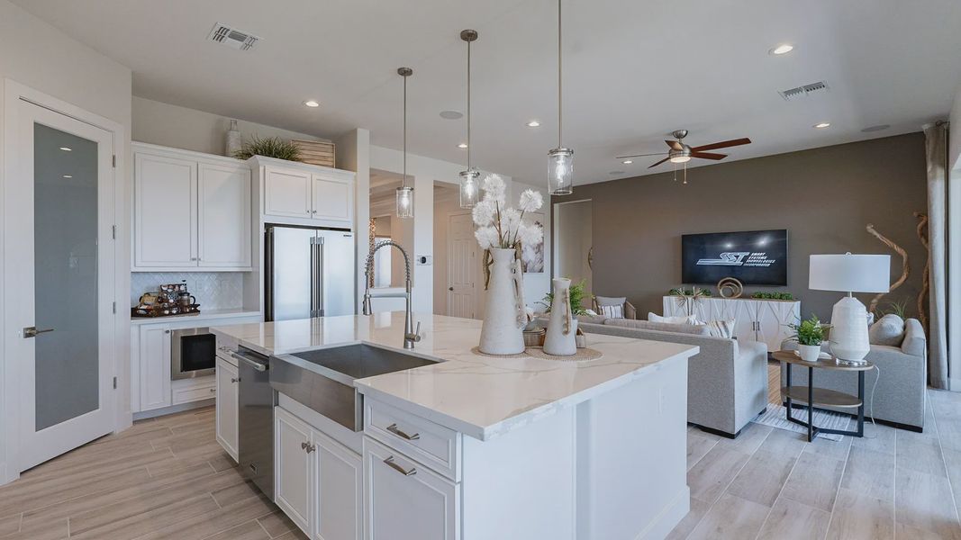 Exquisite open-plan layout with marble countertops, stainless fixtures, and elegant pendant lighting. Windrose community.