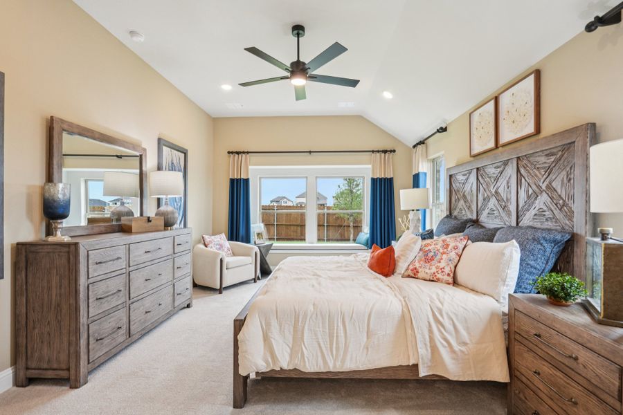 Spacious master bedroom with vaulted ceiling, ceiling fan, rustic wood bed frame, and large dresser with mirror Spacious master bedroom with vaulted ceiling, ceiling fan, rustic wood bed frame, and large dresser with mirror