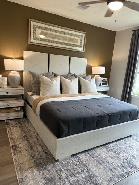 A cozy bedroom with a modern bed, stylish bedding, dual nightstands, and soft lighting complemented by a subtle decorative rug. A cozy bedroom with a modern bed, stylish bedding, dual nightstands, and soft lighting complemented by a subtle decorative rug.