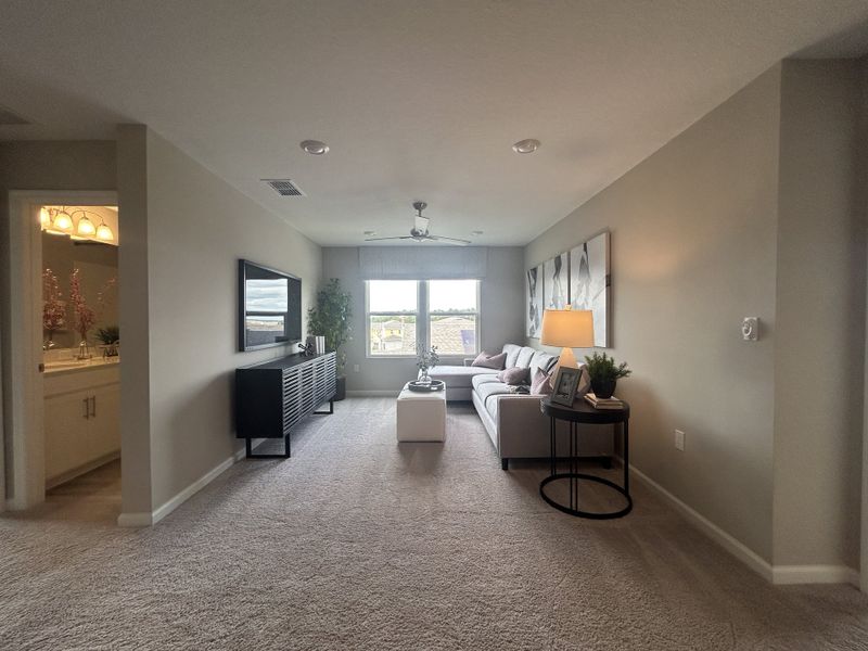 A cozy living room featuring a sleek sectional sofa, large window, wall-mounted TV, and modern decor for a warm ambiance. A cozy living room featuring a sleek sectional sofa, large window, wall-mounted TV, and modern decor for a warm ambiance.