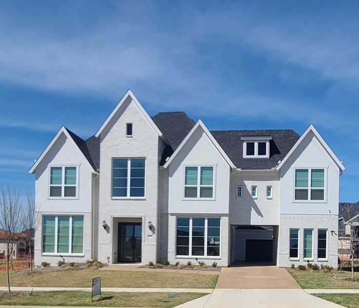 A stunning modern white brick home with elegant windows in Silverleaf Estates by Grand Homes (Frisco, TX).
