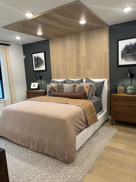 A cozy bedroom featuring warm wood accents, modern lighting, and plush bedding with stylish decor. A cozy bedroom featuring warm wood accents, modern lighting, and plush bedding with stylish decor.