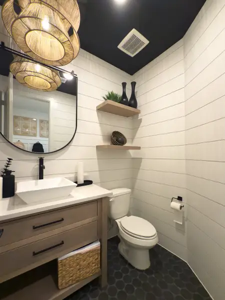 A chic bathroom with shiplap walls, vessel sink, natural wood accents, and woven pendant lighting. A chic bathroom with shiplap walls, vessel sink, natural wood accents, and woven pendant lighting.