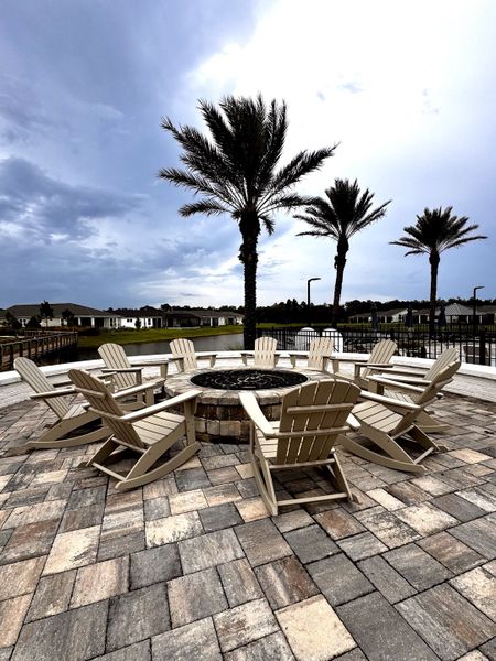 A cozy outdoor fire pit area with Adirondack chairs and palm trees in RiverTown - WaterSong by Mattamy Homes (St. Johns, FL). A cozy outdoor fire pit area with Adirondack chairs and palm trees in RiverTown - WaterSong by Mattamy Homes (St. Johns, FL).