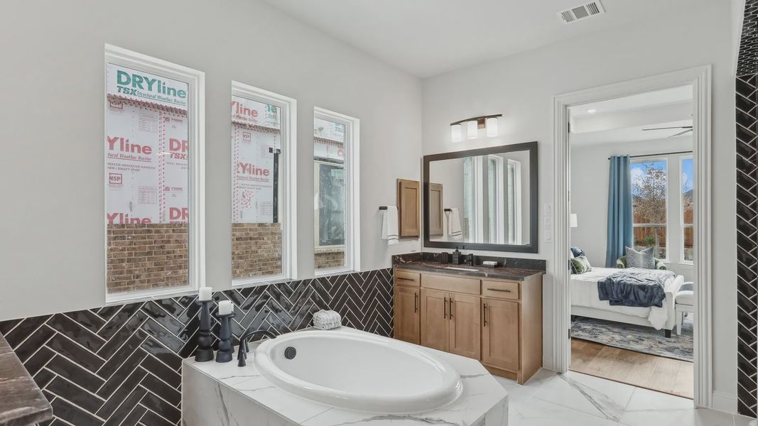 Exquisite marble tub and elegant herringbone tile accent in Green Meadows' luxury home. Exquisite marble tub and elegant herringbone tile accent in Green Meadows' luxury home.