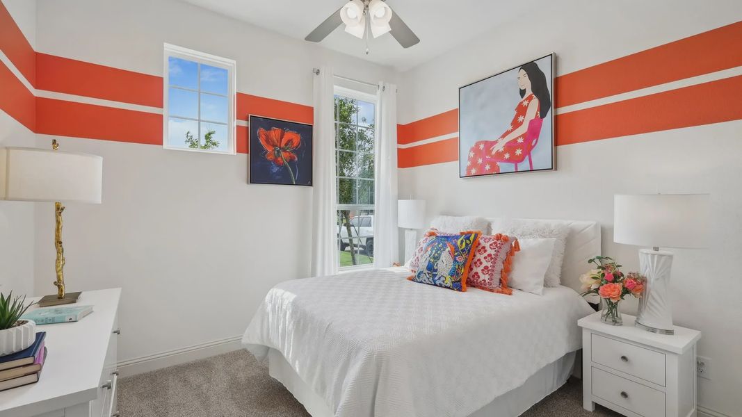 Enjoy vibrant designs and modern amenities in this Heritage Park bedroom, featuring bold orange accents and luxe finishes.