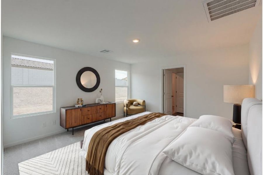 A bedroom with a bed and a mirror.