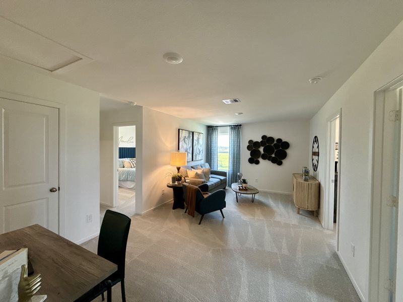 A cozy living area with modern decor, featuring a comfy armchair, sleek furniture, and plenty of natural light.