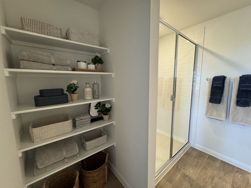 A serene bathroom with built-in shelves, neatly stacked towels, and a glass-enclosed shower in a contemporary design. A serene bathroom with built-in shelves, neatly stacked towels, and a glass-enclosed shower in a contemporary design.