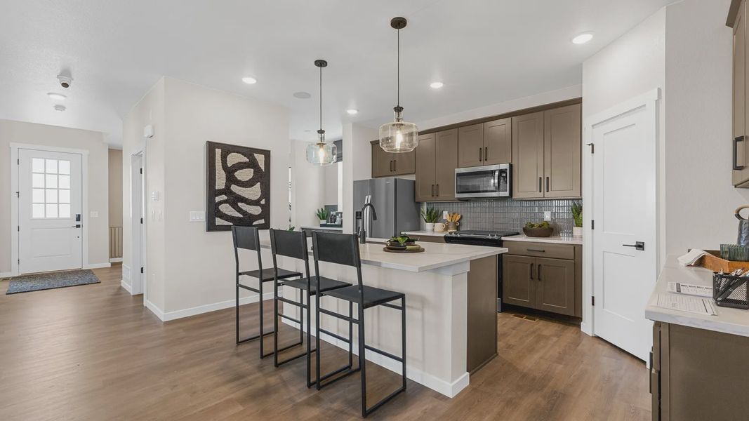Elegant kitchen in Timnath Lakes showcases hardwood floors, sleek cabinetry, and designer pendant lighting. Elegant kitchen in Timnath Lakes showcases hardwood floors, sleek cabinetry, and designer pendant lighting.