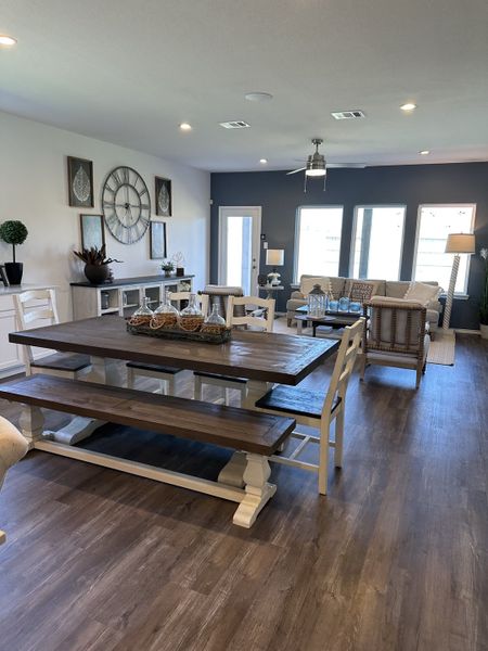 A contemporary open living space with a rustic wooden dining table, stylish decor, and cozy seating area.